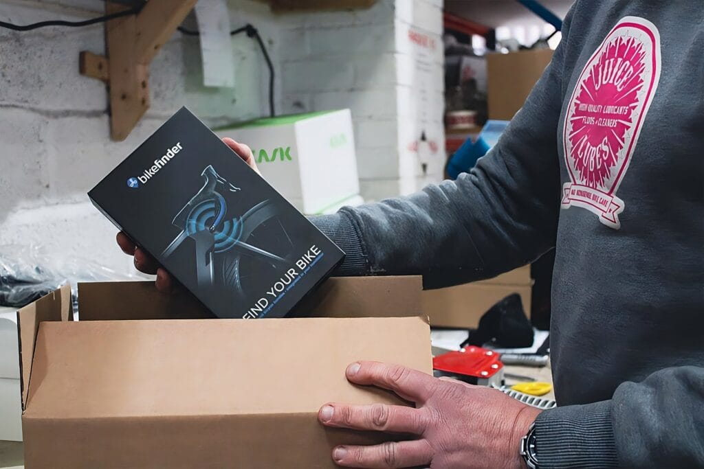 Man picking up bikefinder box from a cardboard box